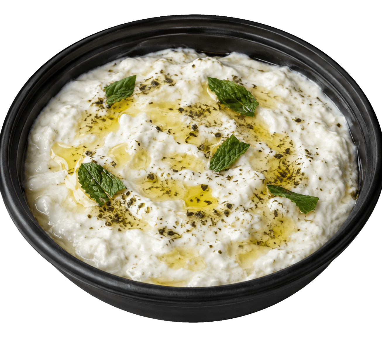 Black bowl of thick white yogurt dip with mint leaves, dried herbs and olive oil.