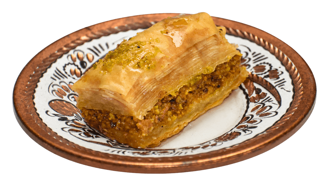 Piece of baklava with layered pastry and nuts on a decorated plate.